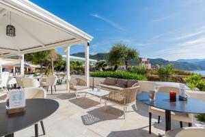 a patio at a hotel with tables and chairs at Mangia's Pollina Resort in Cefalù