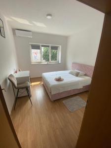 a bedroom with a bed and a chair and a window at Apartman MB in Posušje
