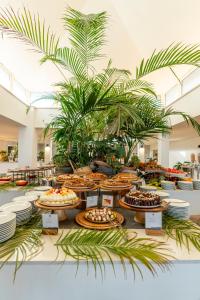 a buffet of food on display in a room with plants at Mangia's Pollina Resort in Cefalù