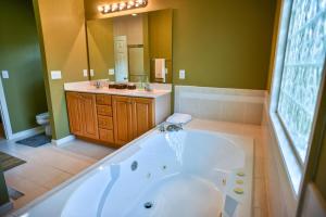 a large bathroom with a tub and a sink at 88 Deerwood Lane in Pinehurst +49 photos