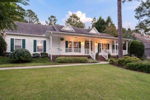 a white house with a porch and a lawn at 88 Deerwood Lane in Pinehurst
