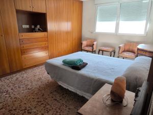 een slaapkamer met een bed, een dressoir en stoelen bij Mirador venerable Escuder ll in Cocentaina