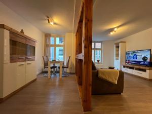 a living room with a couch and a table with a television at Ferienwohnung Hansezauber in städtische Bestlage in Stralsund