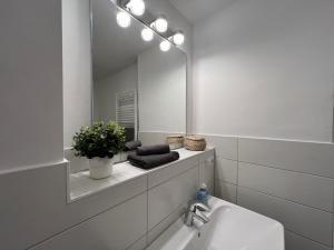 a white bathroom with a mirror and a sink at Ferienwohnung Hansezauber in städtische Bestlage in Stralsund