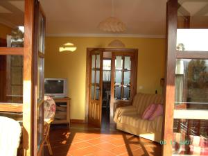 a living room with a couch and a tv at Casa - Apartamentos La Arboleda in Colombres