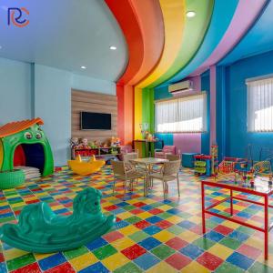 ein Kinderzimmer mit Regenbogendecke und einem Tisch und Stühlen in der Unterkunft Resort Whyndham Royal Star Hotels Olímpia - Thermas dos Laranjais in Olímpia