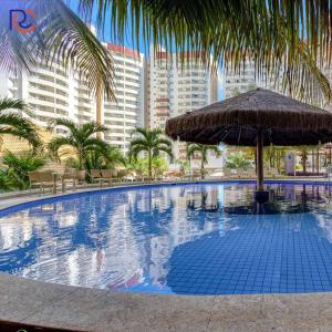 ein großer Swimmingpool mit Sonnenschirm und einigen Gebäuden in der Unterkunft Resort Whyndham Royal Star Hotels Olímpia - Thermas dos Laranjais in Olímpia