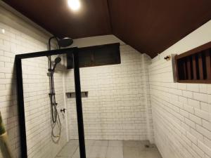 a shower in a bathroom with white brick walls at Banhom Pool villa บ้านหอมพูลวิลล่า in Ban Tha Ton Thong