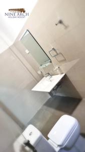 a bathroom with a white toilet and a sink at Ella, Nine Arch Holiday Resort in Ella