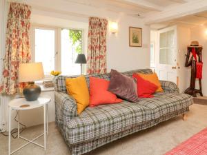 a living room with a couch with colorful pillows at Tawstock View in Barnstaple