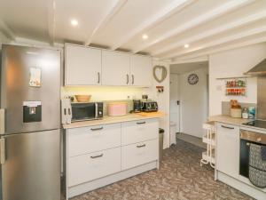 a kitchen with white cabinets and a stainless steel refrigerator at Tawstock View in Barnstaple +27 photos
