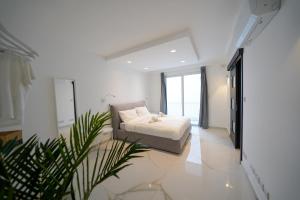 a bedroom with a bed and a plant in it at Luxury brand new holiday apartments TOP location in Is-Swieqi