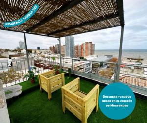 モンテビデオにあるRambla Surの椅子2脚と海の景色が見えるバルコニー