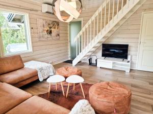 a living room with a couch and a tv at Villa Rantatuuli - 10 henkilölle, Himosranta Beach, 113m² in Jämsä