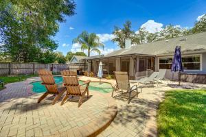 a patio with chairs and a table and a pool at Screened Lanai and Fenced Yard Luxe Orlando Home in Orlando