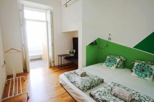 een woonkamer met een groen hoofdbord en een bed bij WOT Patio Social in Lissabon