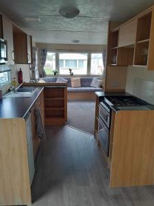 a kitchen with a sink and a stove top oven at Escape to the bay- arnside escapes in Morecambe