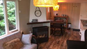 a living room with a couch and a fireplace at Huisje bij de Bronnen in Nutter