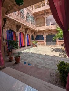 einen leeren Innenhof mit bunten Türen und Topfpflanzen in der Unterkunft Sadar Haveli Heritage in Jodhpur