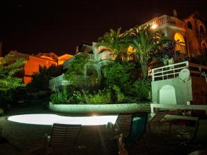 una casa de noche con sillas delante en Villa Clematis, en Trogir