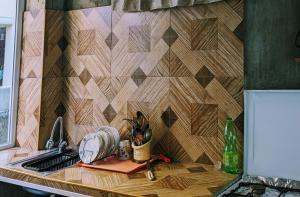a kitchen counter with a wooden tile wall at Vato tkhilaishvili in Kobuleti