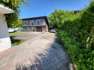 a house with a car parked in front of a driveway at Apartamenty Kacper Grzybowo in Grzybowo