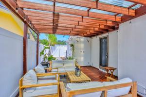 een patio met witte meubels en een houten pergola bij Coquina Treasure in Seminole