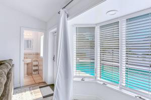 een badkamer met een bad en een raam met jaloezieën bij Coquina Treasure in Seminole