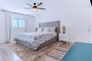 una camera da letto con un letto e un ventilatore a soffitto di Coquina Treasure a Seminole Altre 34 foto