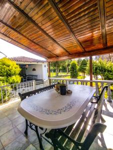 a table on a patio with a wooden pergola at Oasis Cottage in Krepeni