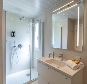a bathroom with a sink and a shower with a mirror at Mangia's Pollina Resort in Cefalù