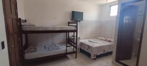 a room with two bunk beds and a television at Pousada Chalet La Pink in Canoa Quebrada