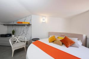 a bedroom with a bed with orange and yellow pillows at Rooftop 19_Amalfi Luxury Suite in Amalfi