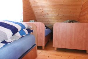 a bedroom with two beds and a wooden wall at Mandarynka OW in Jarosławiec