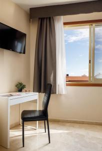 Televízia a/alebo spoločenská miestnosť v ubytovaní Hotel Alguer