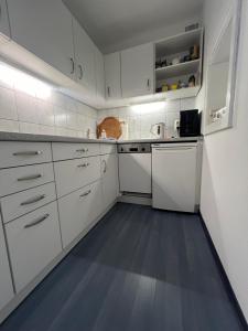a kitchen with white cabinets and a blue floor at Wilder Klaus in Wangerooge