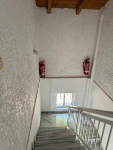 a staircase in a building with two red containers on the wall at Paris sea view studio in Platamonas