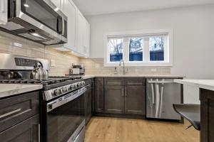 a kitchen with stainless steel appliances and wooden cabinets at 3BR2Bth MIT Harvard TD Garden BOS 2 Parking Spaces in Somerville