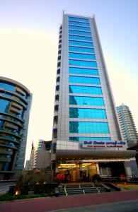un edificio alto con ventanas azules en una ciudad en Gulf Oasis Hotel Apartments Fz LLC, en Dubái