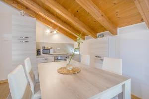 Un comedor con una mesa y sillas blancas. en Stazione 200m - Wifi - Aria condizionata - Smart TV, en Parma