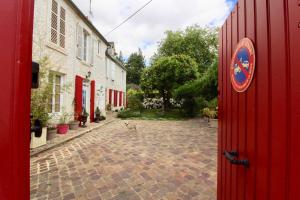 a red door with a sign on the side of a building at Aggarthi Bed and Breakfast in Bayeux