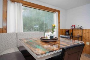 a dining room with a table and a large window at Meadow Rue Retreat in Dennis Manor