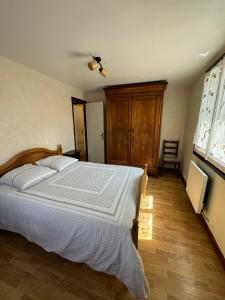 朗热Maisons du château的卧室配有一张白色床和木地板