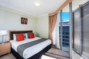 a bedroom with a bed and a large window at Mantra on Mary in Brisbane