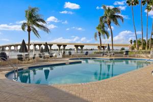 Una piscina con palmeras y un puente al fondo. en New Listing Bahia Vista 8 411 2BD 2BA, en Tierra Verde
