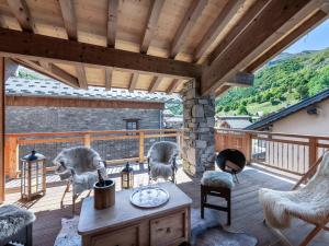 a wooden deck with chairs and a stone fireplace at Duplex Montagne Spacieux avec Cheminée, 4 Chambres - FR-1-570-21 in Praranger
