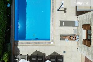 kobieta leżąca obok basenu w obiekcie Atsipopoulo Villas w mieście Atsipopoulo