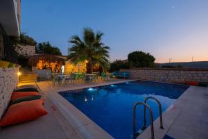 a swimming pool with a patio and a table at Kybele Alaçatı in İzmir