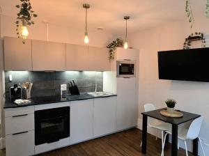 a kitchen with a table and a white refrigerator at Bienvenue dans la Jungle in Dreux