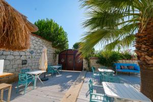 un patio con tavoli, sedie e una palma di Kybele Alaçatı a Smirne